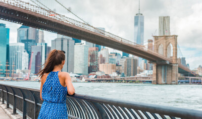 New York City woman looking at Brooklyn Bridge and view of downtown Manhattan skyline from Brooklyn...