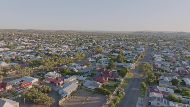 Early morning sunrise high angle aerial drone footage of the historic outback mining town of Broken Hill, New South Wales, Australia. Flying over residential and business districts. Shot in 60 fps.