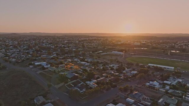 Early morning sunrise high angle aerial drone footage of the historic outback mining town of Broken Hill, New South Wales, Australia. Flying over residential and business districts. Shot in 60 fps.