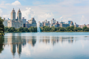 Fototapeta na wymiar Central park lake view of New York City skyline in summer. USA travel vacation destination, reflection of buildings in water