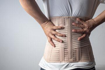 Man wearing back support belt for back pain and spine.Medical concept.