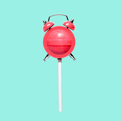 Fun funny candy on a stick and retro alarm clock. Minimal concept of sweets and deadline. High...