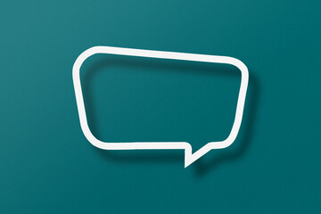 Naklejka premium White paper cut out speech bubble shape set on green paper background.