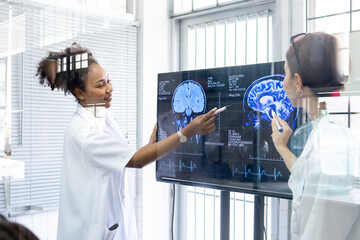 View through glass, Team doctor presentation of brain x-ray results through screen to present to...