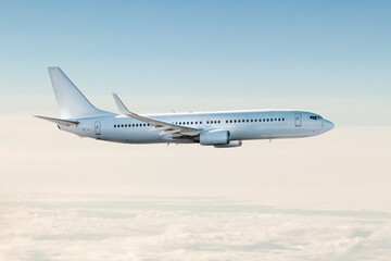 Fototapeta na wymiar White passenger jet plane flies in the air above the clouds