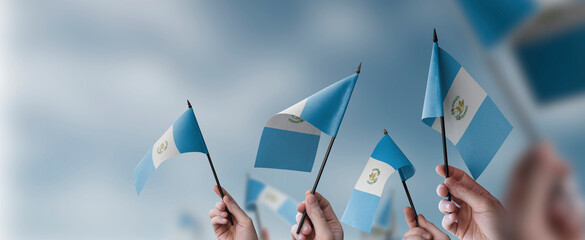 A group of people holding small flags of the Guatemala in their hands
