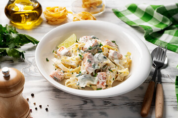 Italian made fettuccine pasta with creamy sauce and grilled salmon. - 577903183