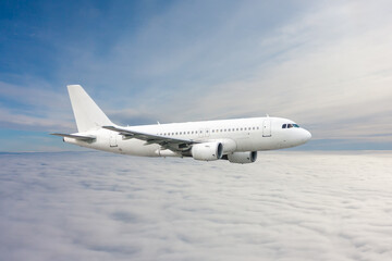 Fototapeta na wymiar White passenger jetliner fly in the air above the clouds