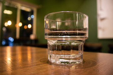 glass of water on a table at a coffee shop at night.