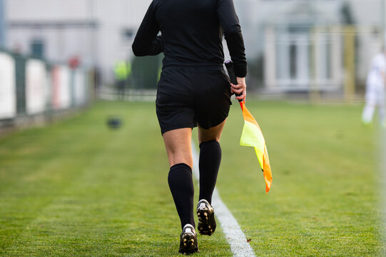 A female assistant referee runs by the touchline
