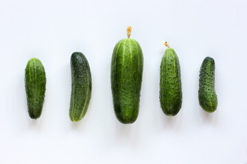 green fresh cucumbers on a white background, flat lay.