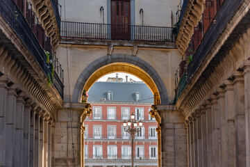 Obraz premium One of the entrance arches that give access to the main square of Madrid with its typical buildings of ancient times, Spain.