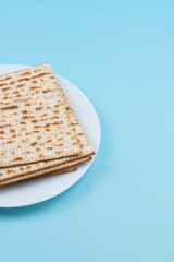Matzah on the plate on blue background. Pesah Passover holiday celebration dinner concept.