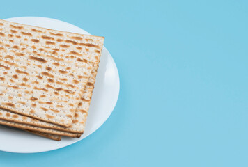 Matzah on the plate on blue background. Pesah Passover holiday celebration dinner concept.