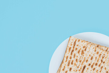 Matzah on the plate on blue background. Pesah Passover holiday celebration dinner concept.