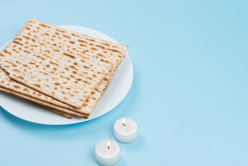 Matzah and Shabbat candles on blue background. Pesah Passover holiday celebration dinner concept.