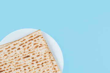 Matzah on the plate on blue background. Pesah Passover holiday celebration dinner concept.