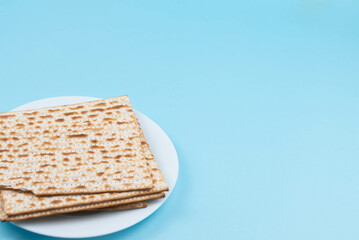 Matzah on the plate on blue background. Pesah Passover holiday celebration dinner concept.