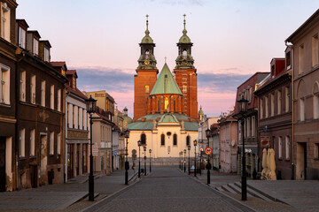 Naklejka na ściany i meble Historical road leading towards Gniezno Royal Cathedral on a sunset.