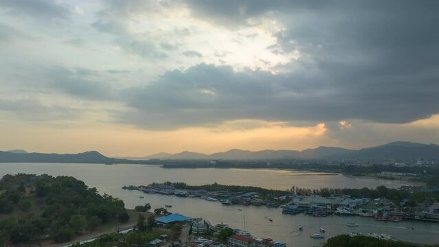 aerial hyperlapse view large canal at the largest Phuket fishing port and Phuket shipyard. .aerial view beautiful cloud in sunset above Phuket fishing port. fishing boats background..