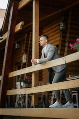 portrait of the groom in a gray suit and an orange vest