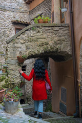 Beautiful young woman sitting on the wall. Look at his house in the fortress. Caucasian woman in...