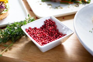 A view of a condiment cup of red peppercorns.