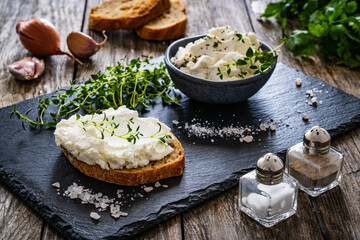 Cottage cheese sandwich with thyme on wooden table
