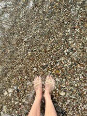 feet in water on pebble beach