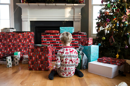 Rear View of Blonde Boy Looking at Large Stack of Christmas Presents