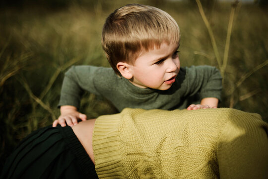 Little boy and his mother playing on green meadow