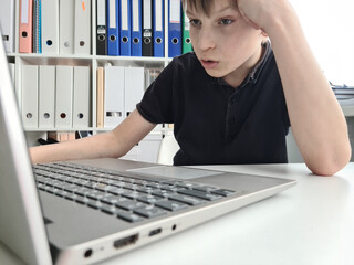 Boy boy makes homework computer. Sad child is tired of tired is sad child © Nadzeya