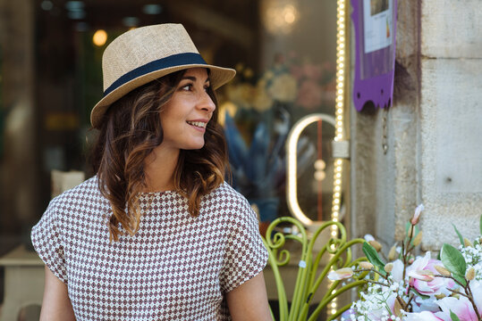Portarit of pretty woman siting in front of florist in France.