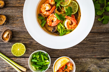 Thai seafood soup on wooden table
