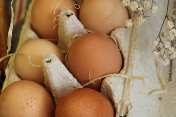 Homemade chicken eggs lie in a tray in straw. Close-up. Cooking and recipes, eco, healthy eating,...