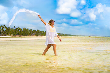 Fototapeta na wymiar Beach holiday - beautiful woman walking on sunny, tropical beach 
