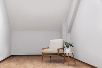 Fototapeta na wymiar Attic spacious room interior with slanted ceiling and furniture