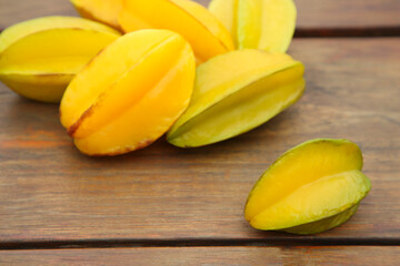 Delicious ripe carambolas on wooden table, closeup