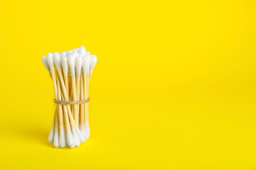 Fototapeta na wymiar Bunch of new cotton buds on yellow background. Space for text