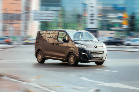 Citroen Jumpy van in the city street. Front side view of brown light commercial vehicle in motion