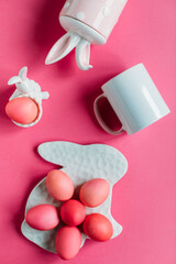 Easter composition with painted pink eggs and decorative figures with rabbits