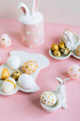 Obraz na płótnie Canvas Golden glitter Easter eggs on plate in shape of rabbit on pink background