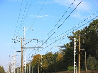 electric poles, towers and wires near railway tracks in summer