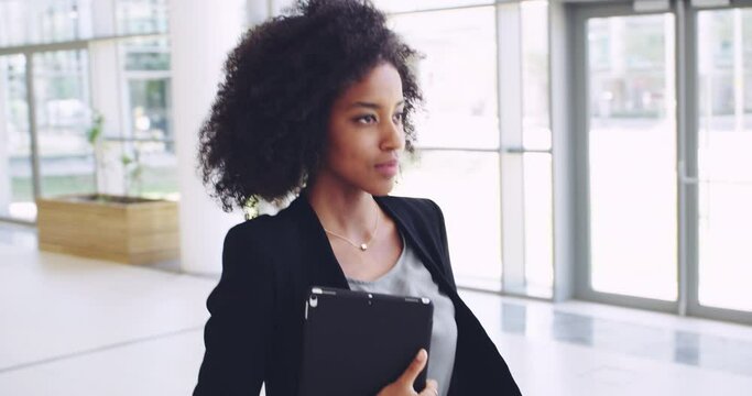 She and confidence are best friends. 4k video footage of a young confident businesswoman walking with a digital tablet and showing a friendly hand gesture to the camera at work.