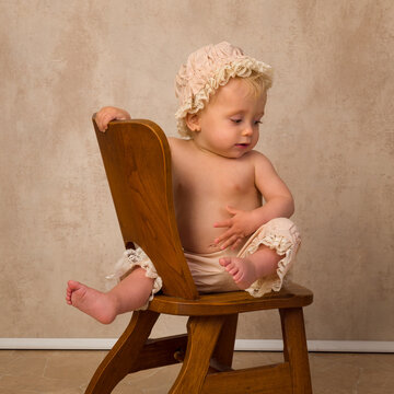Portrait of Blonde baby on vintage chair