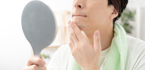 髭剃り後の顎を気にする男性