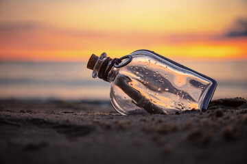 Fototapeta na wymiar Message in the bottle against the Sun setting down