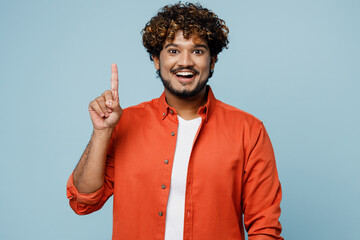 Young insighted smart proactive Indian man wear orange red shirt white t-shirt holding index finger...
