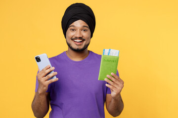 Traveler Sikh Indian man wear turban dastar purple t-shirt hold passport ticket mobile cell phone...