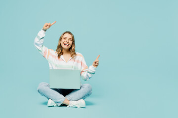 Full body smiling happy young IT woman wear striped hoody sitting hold use work on laptop pc...